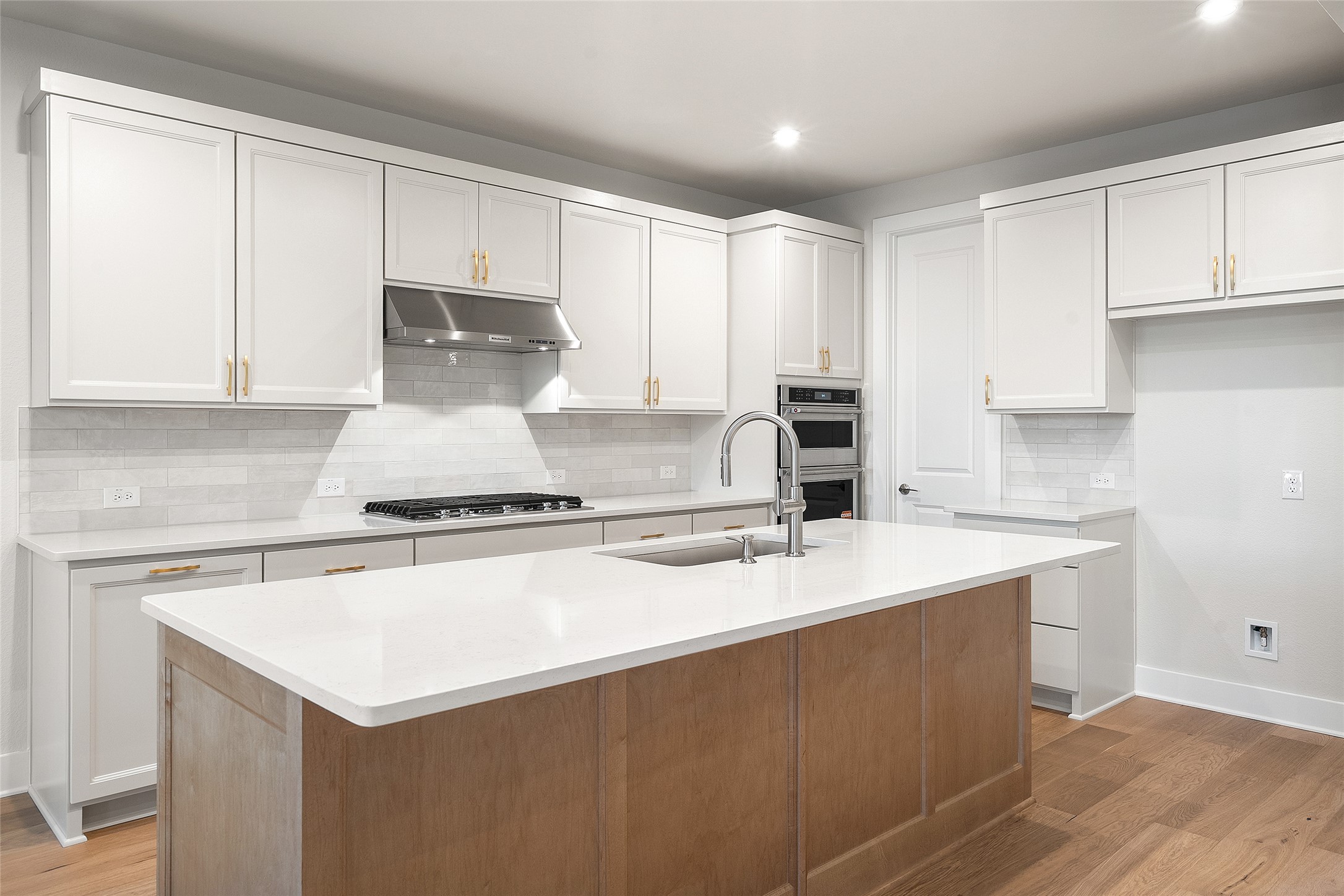 5336 Cosenza Trace Leander, TX 78641 - Photo 14 of 40 Kitchen with brown cabinetry, white cabinets, backsplash, recessed lighting, and an island with sink