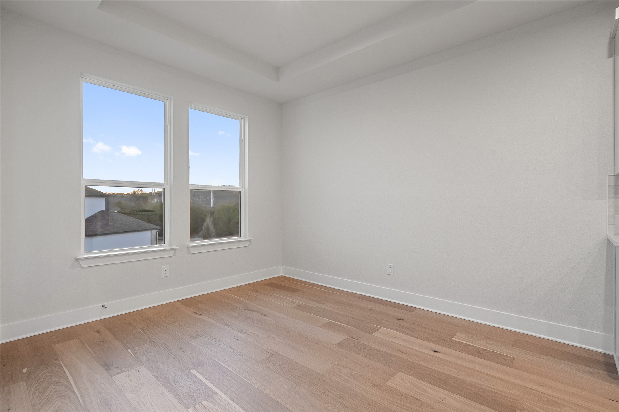 5336 Cosenza Trace Leander, TX 78641 - Photo 17 of 40 Unfurnished room featuring light wood-type flooring and a tray ceiling
