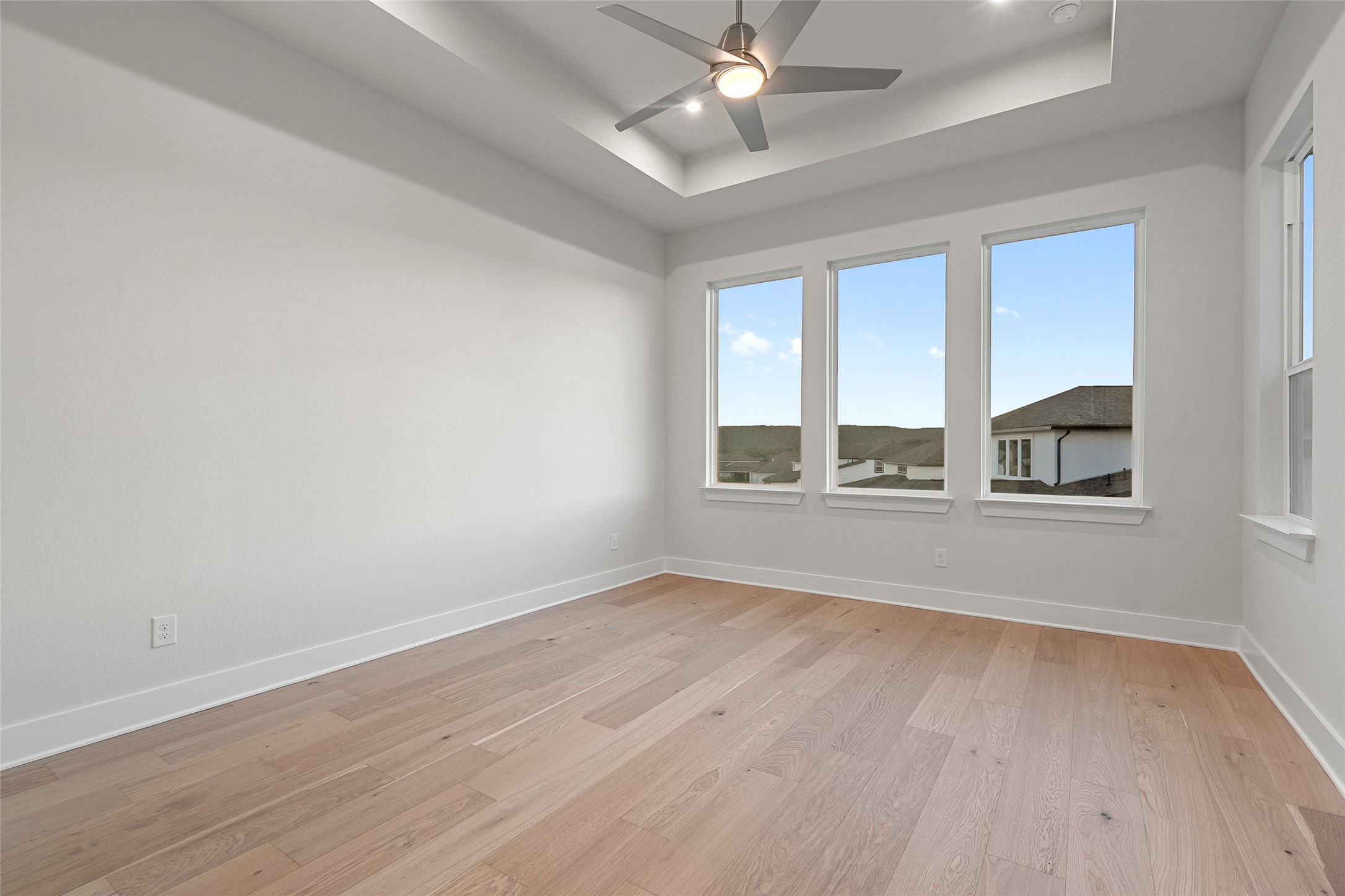 5336 Cosenza Trace Leander, TX 78641 - Photo 19 of 40 Spare room featuring light wood finished floors, a raised ceiling, ceiling fan, and recessed lighting
