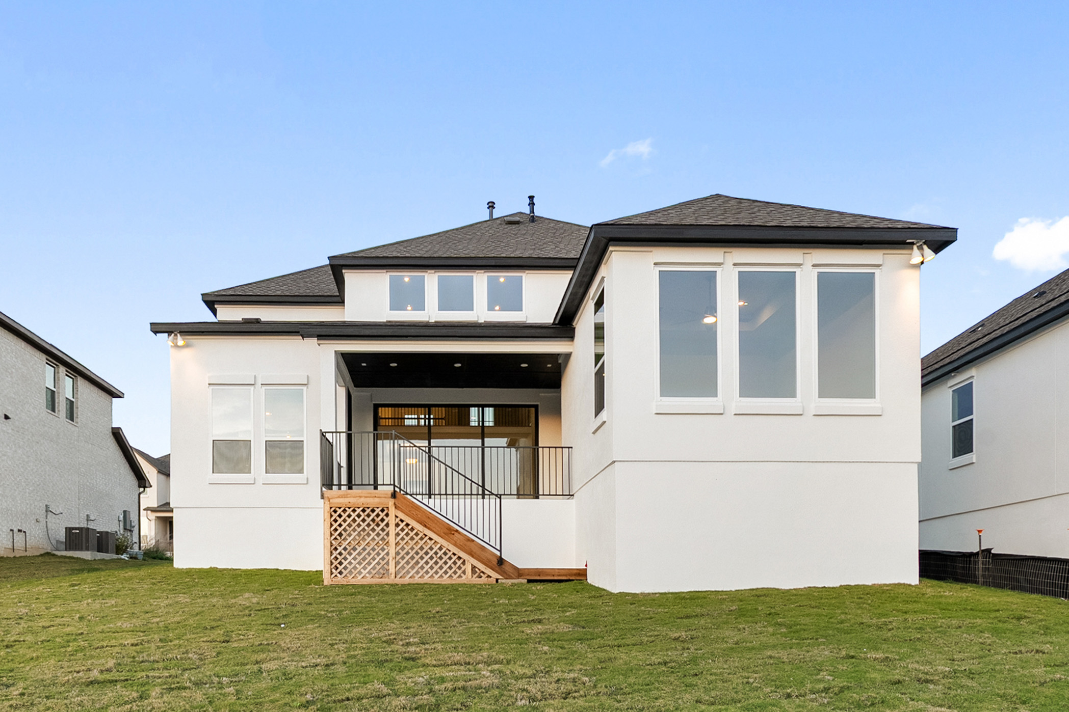 5336 Cosenza Trace Leander, TX 78641 - Photo 36 of 40 Rear view of house with a lawn, stucco siding, roof with shingles, and stairway