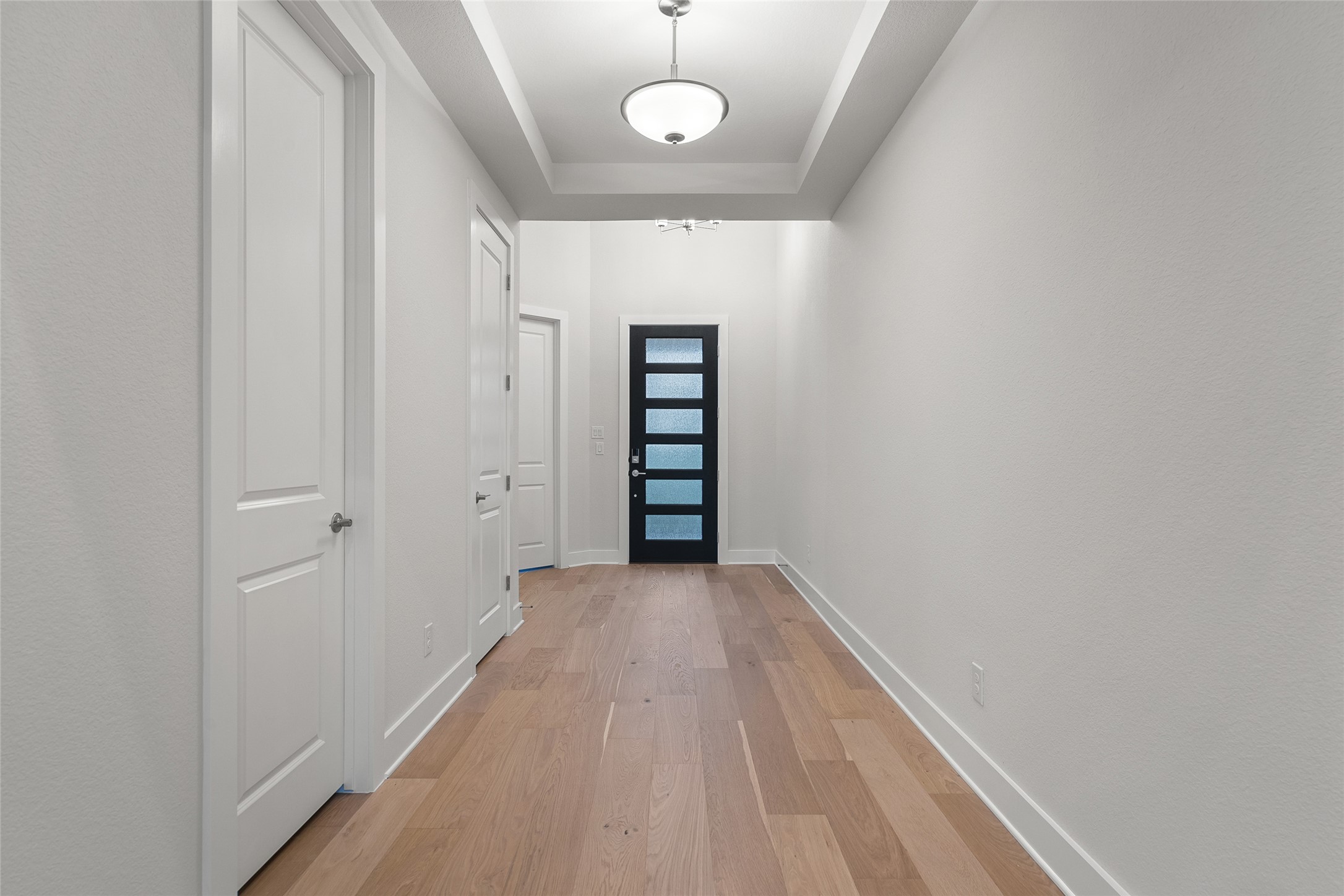 5336 Cosenza Trace Leander, TX 78641 - Photo 5 of 40 Doorway to outside featuring wood finished floors and a tray ceiling