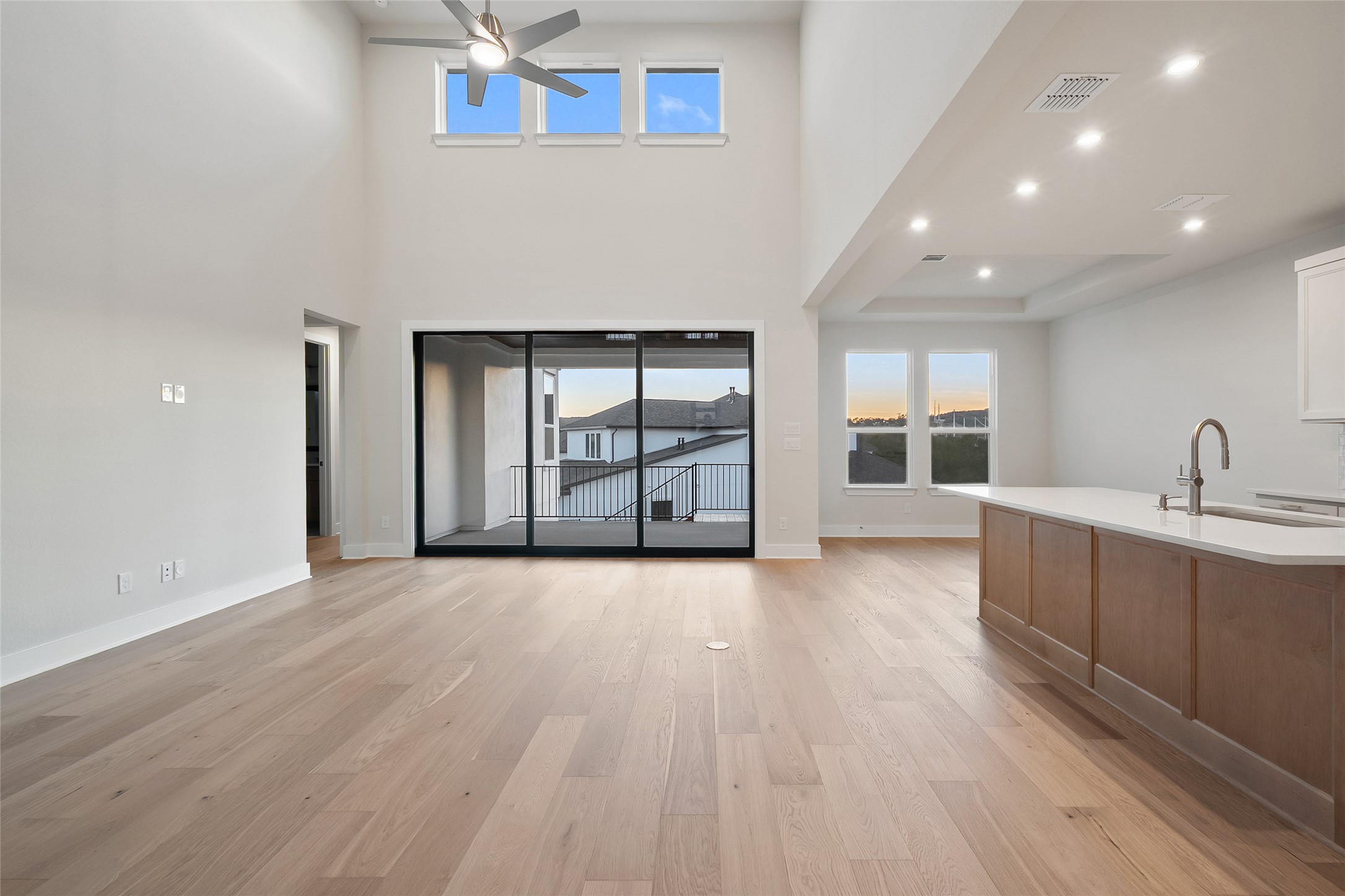 5336 Cosenza Trace Leander, TX 78641 - Photo 8 of 40 Unfurnished living room featuring light wood-type flooring, recessed lighting, ceiling fan, and a towering ceiling