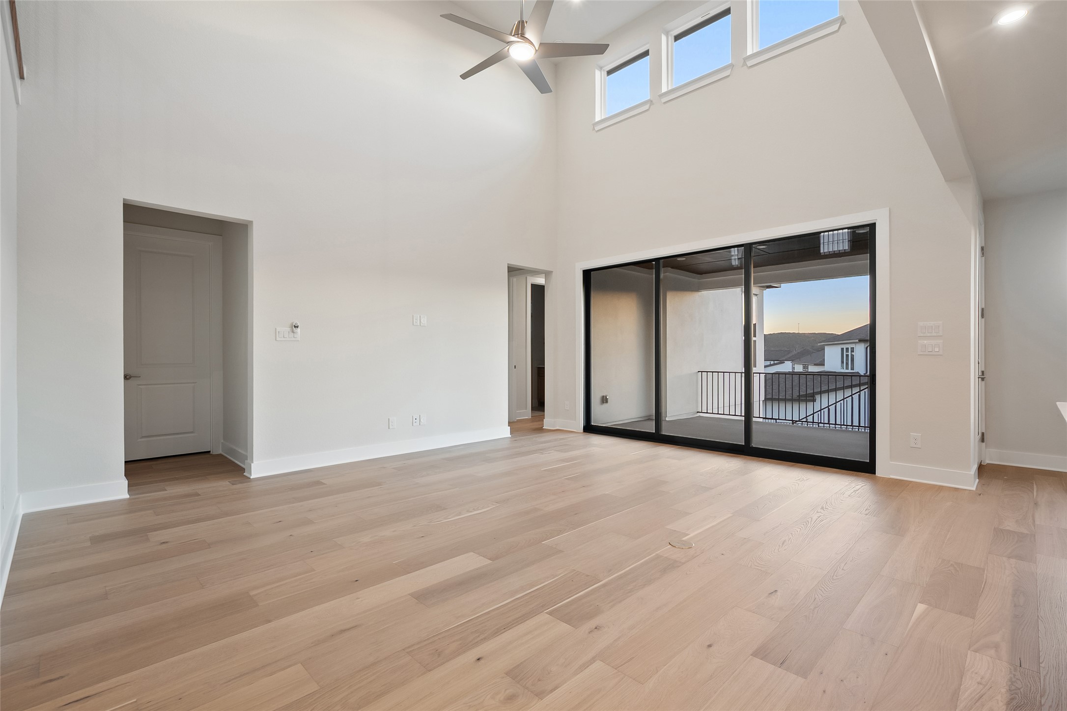 5336 Cosenza Trace Leander, TX 78641 - Photo 9 of 40 Unfurnished room with ceiling fan, light wood-style floors, and a towering ceiling