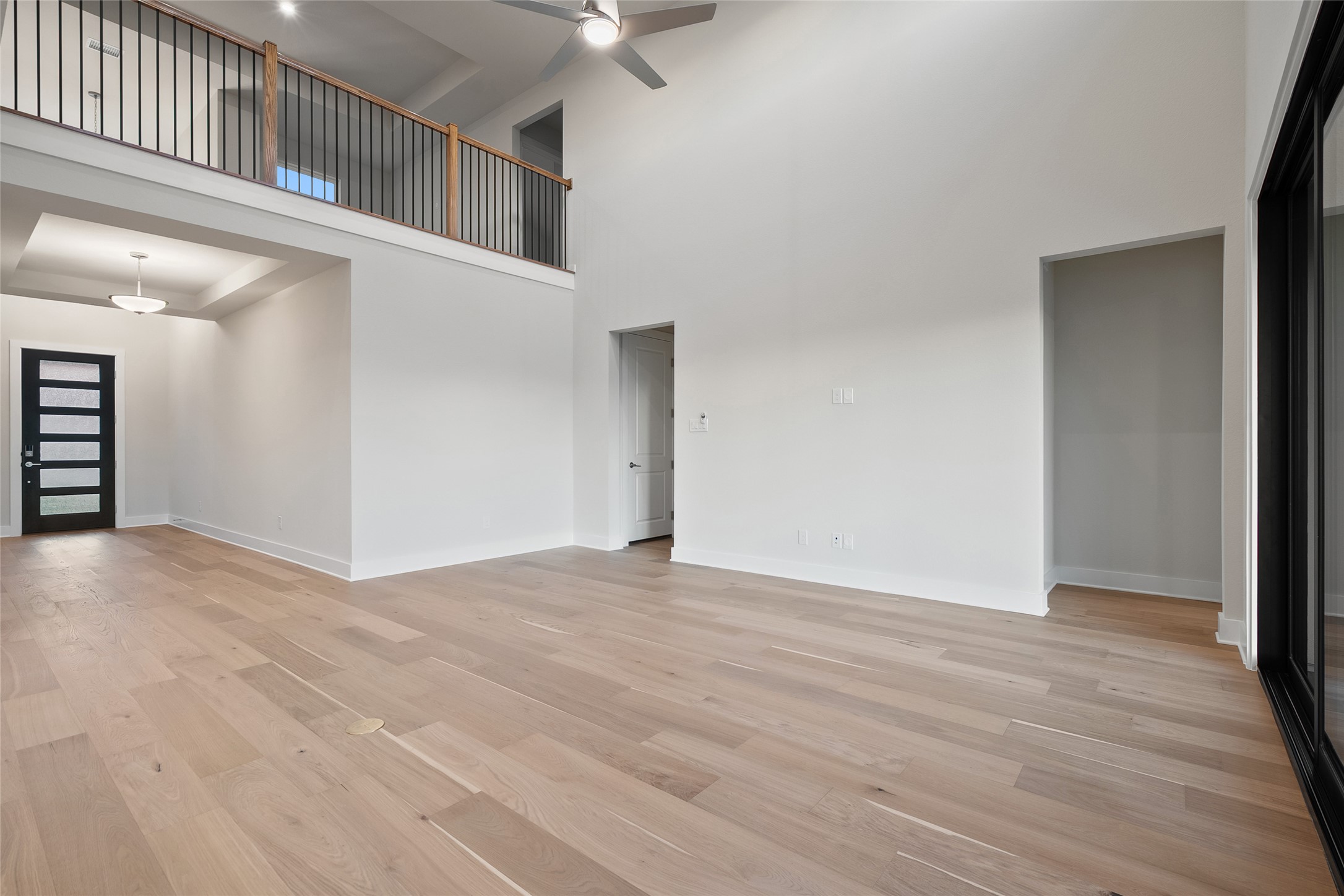 5336 Cosenza Trace Leander, TX 78641 - Photo 10 of 40 Spare room featuring a towering ceiling, light wood finished floors, and a ceiling fan