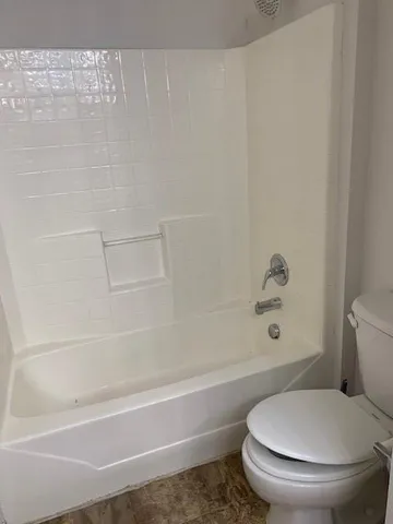 a white toilet and tub sitting next to a bathroom sink