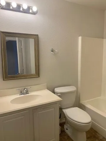 a bathroom with a toilet a sink and mirror