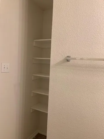 a view of walk in closet with empty racks