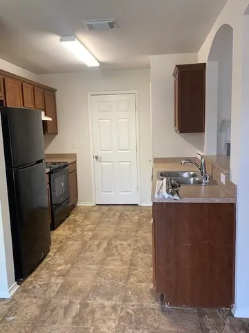 a kitchen with stainless steel appliances granite countertop a refrigerator and a sink
