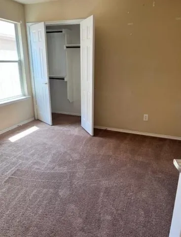an empty room with closet and windows