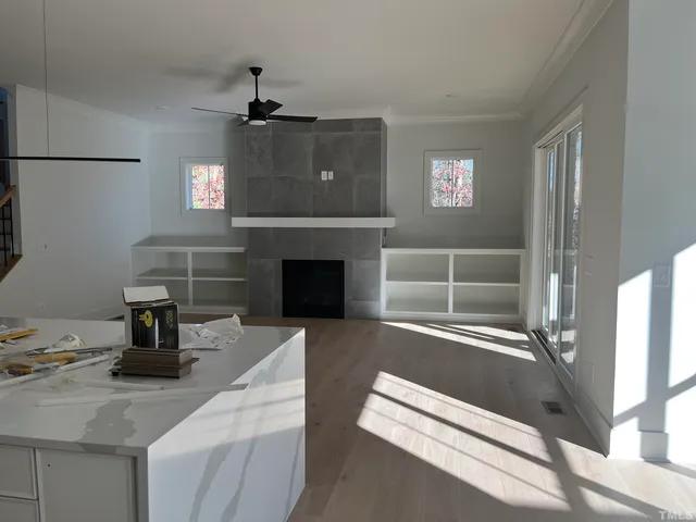 a view of empty room with wooden floor and fireplace
