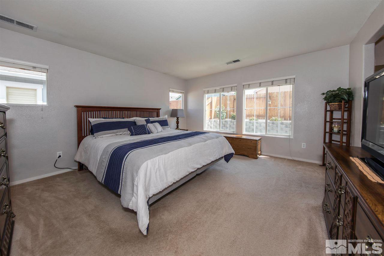 7690 Appenzell Street Reno, NV 89506 - Photo 13 of 25 a bed sitting in a bedroom next to a window