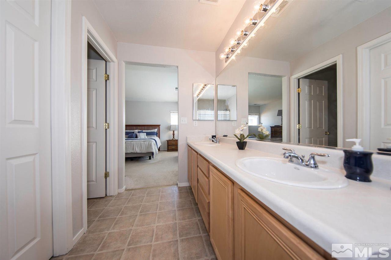 7690 Appenzell Street Reno, NV 89506 - Photo 16 of 25 a en suite bathroom with a sink and a mirror