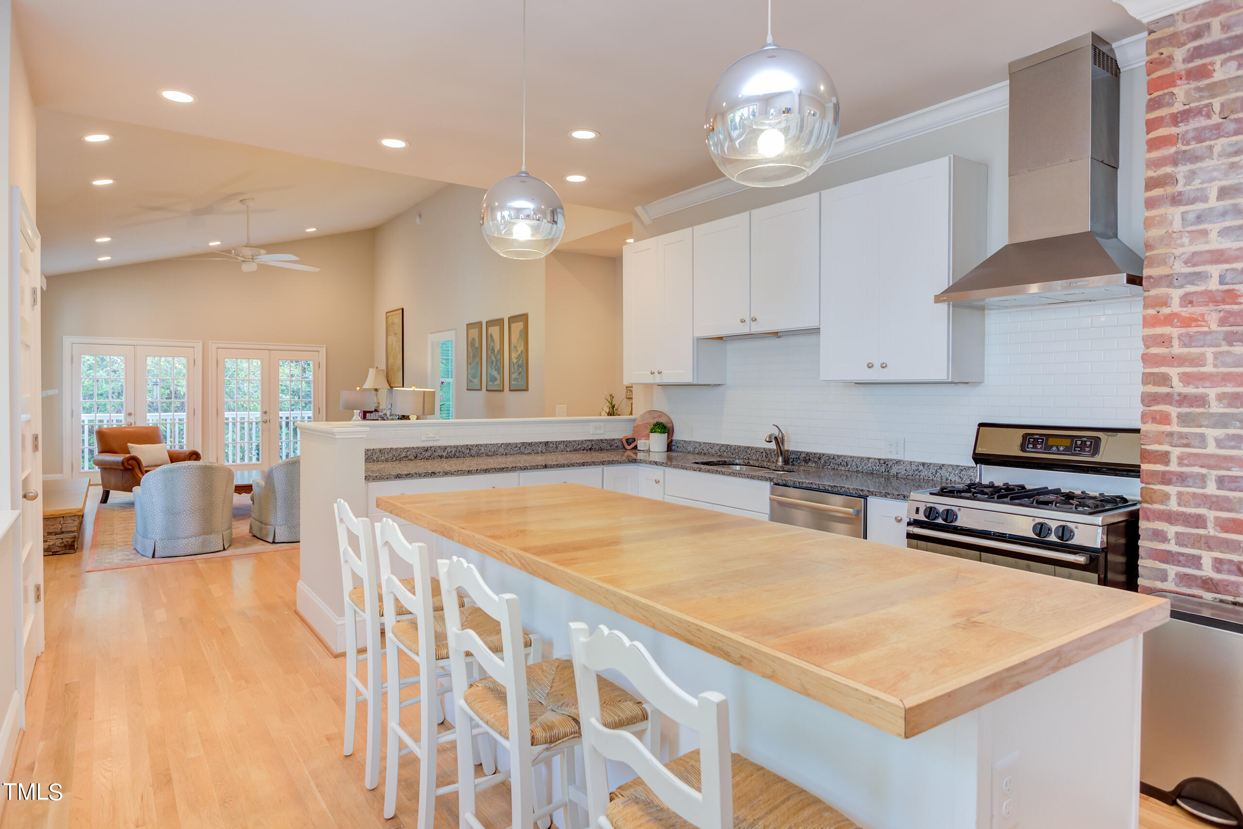 2222 Creston Road Raleigh, NC 27608 - Photo 12 of 57 a large kitchen with stainless steel appliances a stove a sink dishwasher and a refrigerator with wooden floor