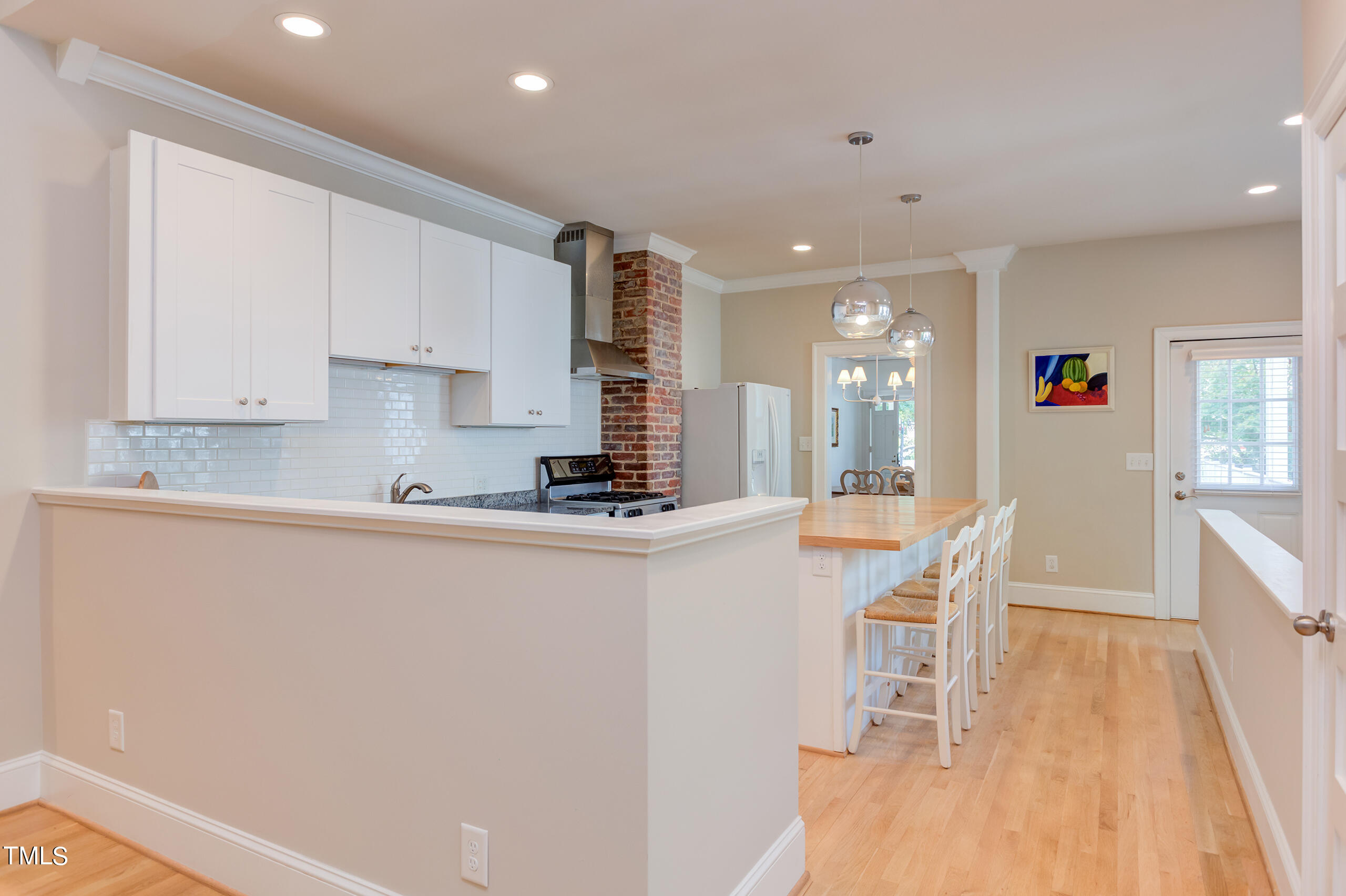 2222 Creston Road Raleigh, NC 27608 - Photo 15 of 57 a kitchen with stainless steel appliances granite countertop a sink a stove a refrigerator a microwave with white cabinets and wooden floor