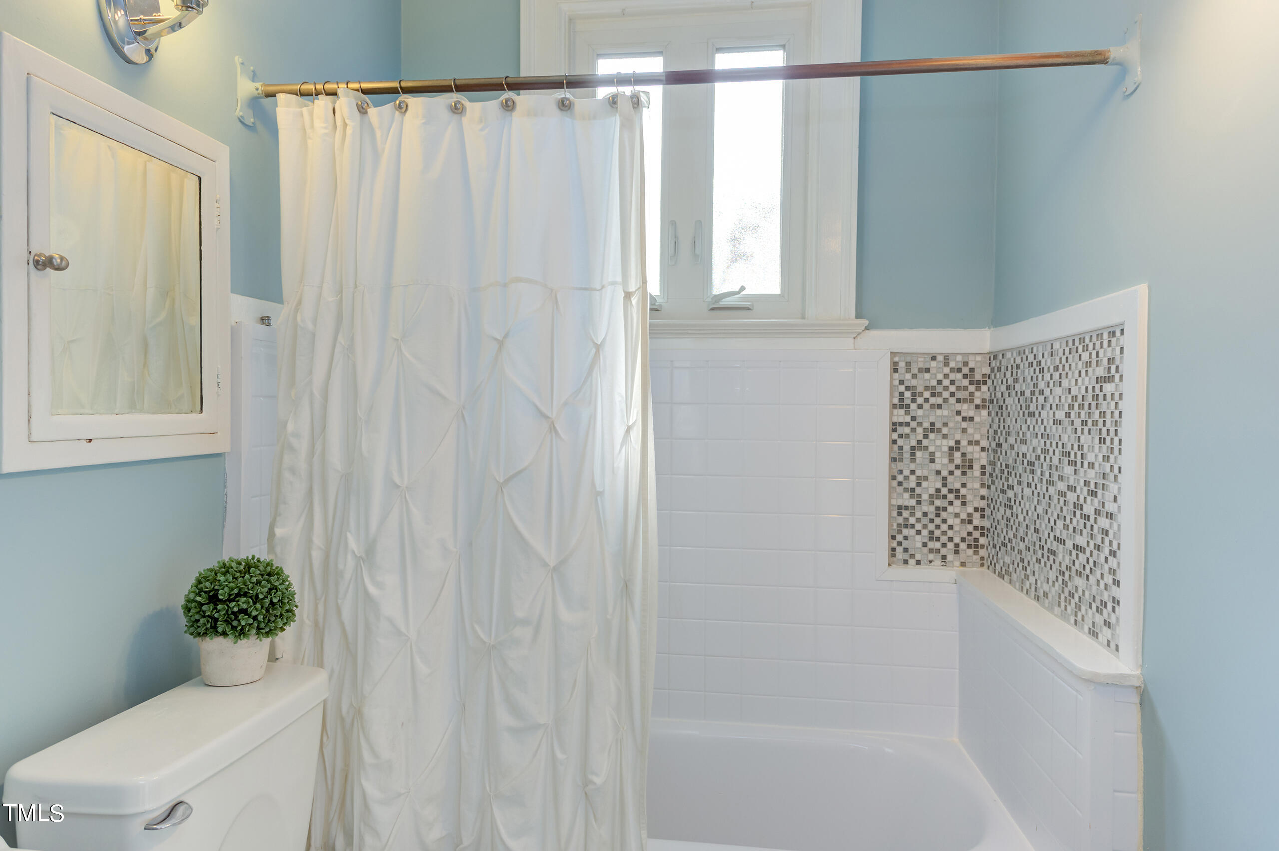 2222 Creston Road Raleigh, NC 27608 - Photo 36 of 57 a bathroom with a shower curtain and a toilet