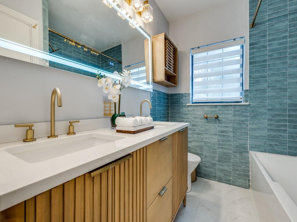 5739 Ellsworth Avenue Dallas, TX 75206 - Photo 32 of 38 a bathroom with a sink a mirror and a bathtub