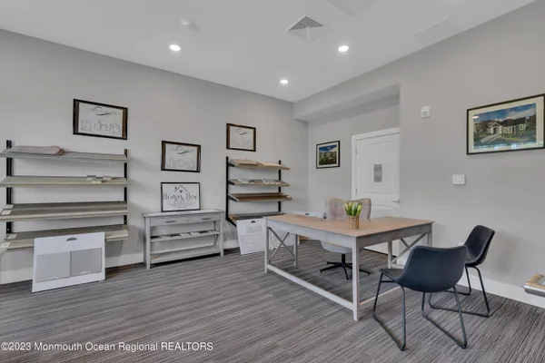 a view of a workspace with furniture and wooden floor