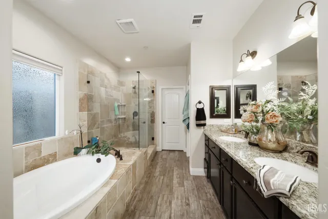 a large spacious bathroom with a granite countertop tub sink and mirror