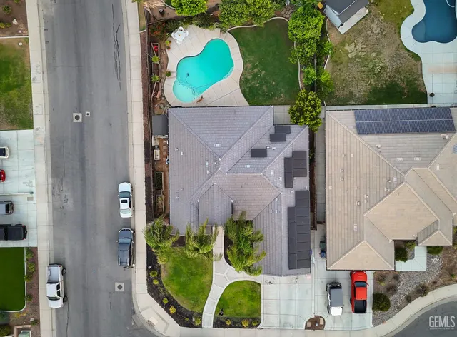 an aerial view of a house with swimming pool and a yard