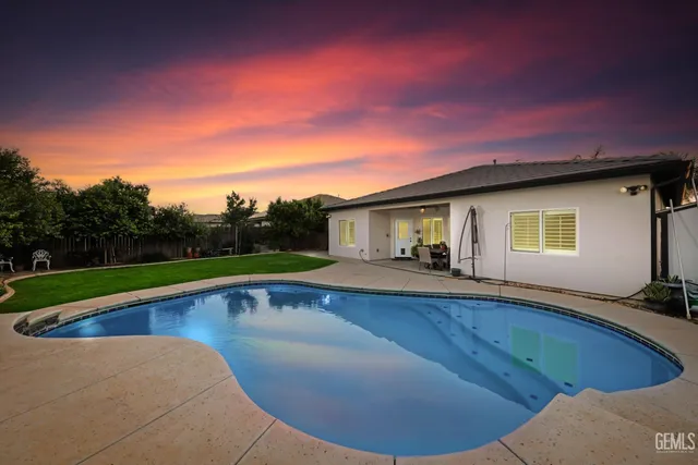 a view of a house with swimming pool and yard
