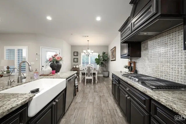a kitchen with stainless steel appliances granite countertop a sink stove and cabinets