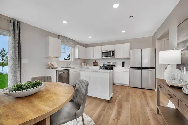 a kitchen with white cabinets and refrigerator