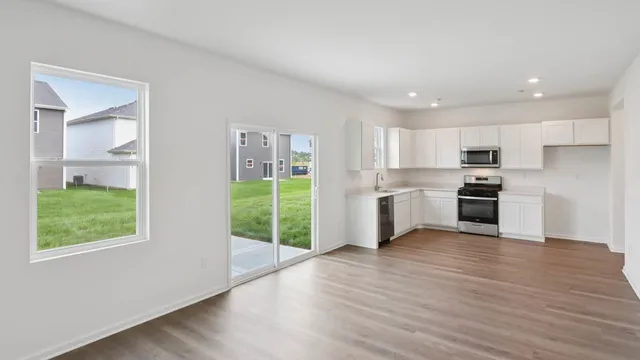 a kitchen with granite countertop a refrigerator and wooden floor