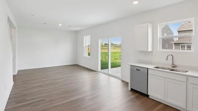 a view of a kitchen with sink and dishwasher with wooden floor