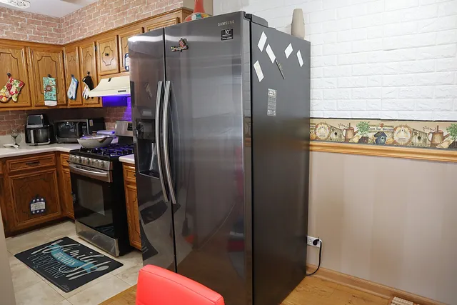 a kitchen with stainless steel appliances granite countertop a refrigerator and a stove