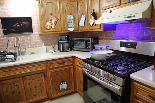 a kitchen with stainless steel appliances granite countertop a stove a sink and a microwave