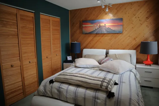 a bedroom with a bed and a wall painting