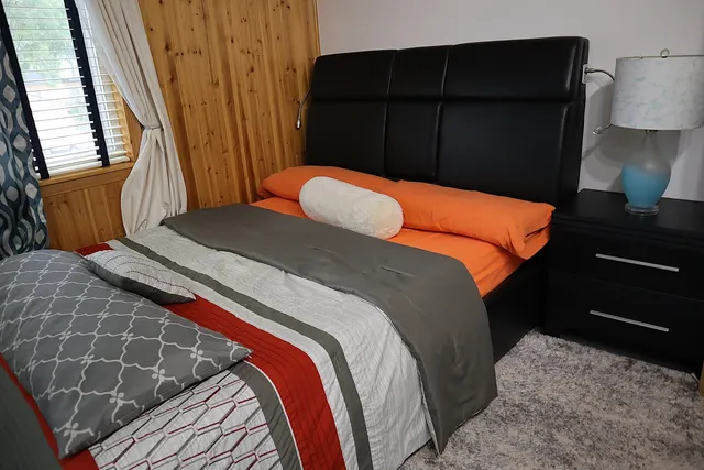 a bedroom with a bed and wooden floor