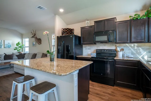 a kitchen with stainless steel appliances kitchen island granite countertop a kitchen island hardwood floor sink and stove