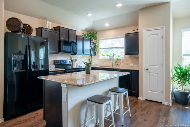 a kitchen with stainless steel appliances kitchen island a refrigerator and a sink