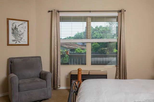 a bedroom with furniture and a large window