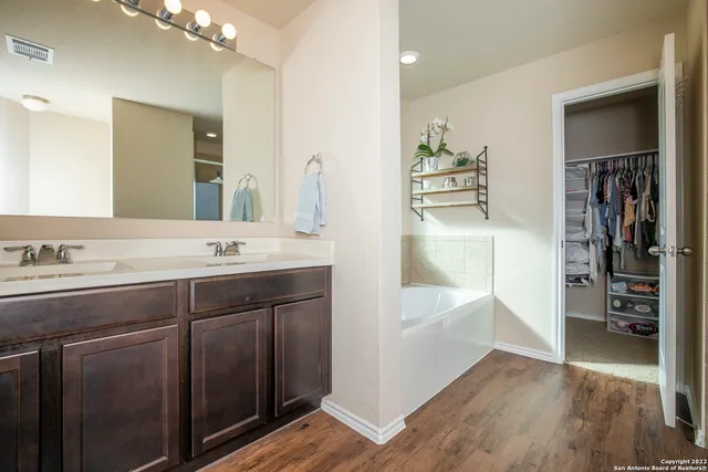 a bathroom with a tub sink and mirror