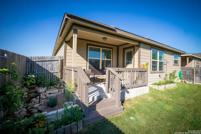 a view of a house with backyard and sitting area