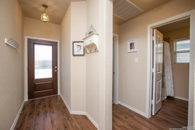 a view of a hallway with wooden floor and closet