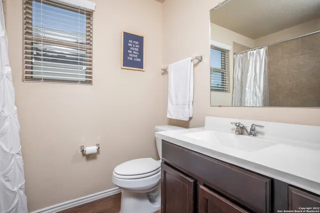 a bathroom with a sink mirror vanity and toilet