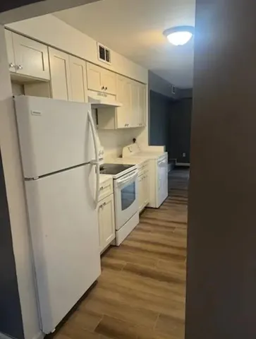 a view of a hallway with wooden floor