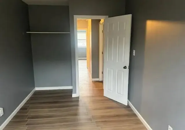 a view of an empty room with wooden floor