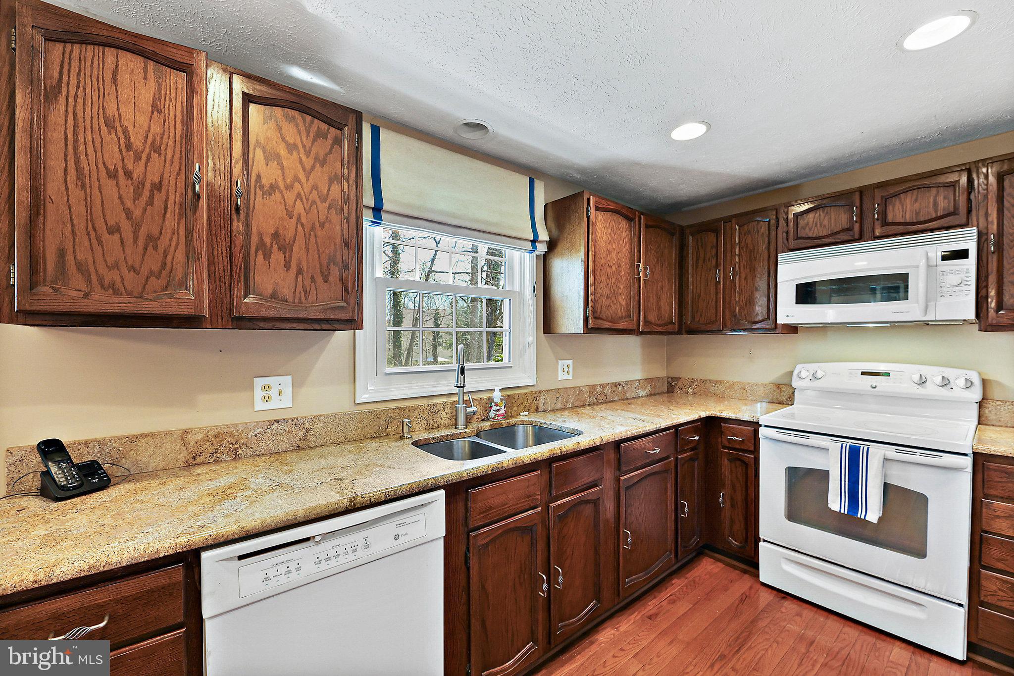 8470 Falling Leaf Road Springfield, VA 22153 - Photo 13 of 41 a kitchen with a sink stove top oven and cabinets