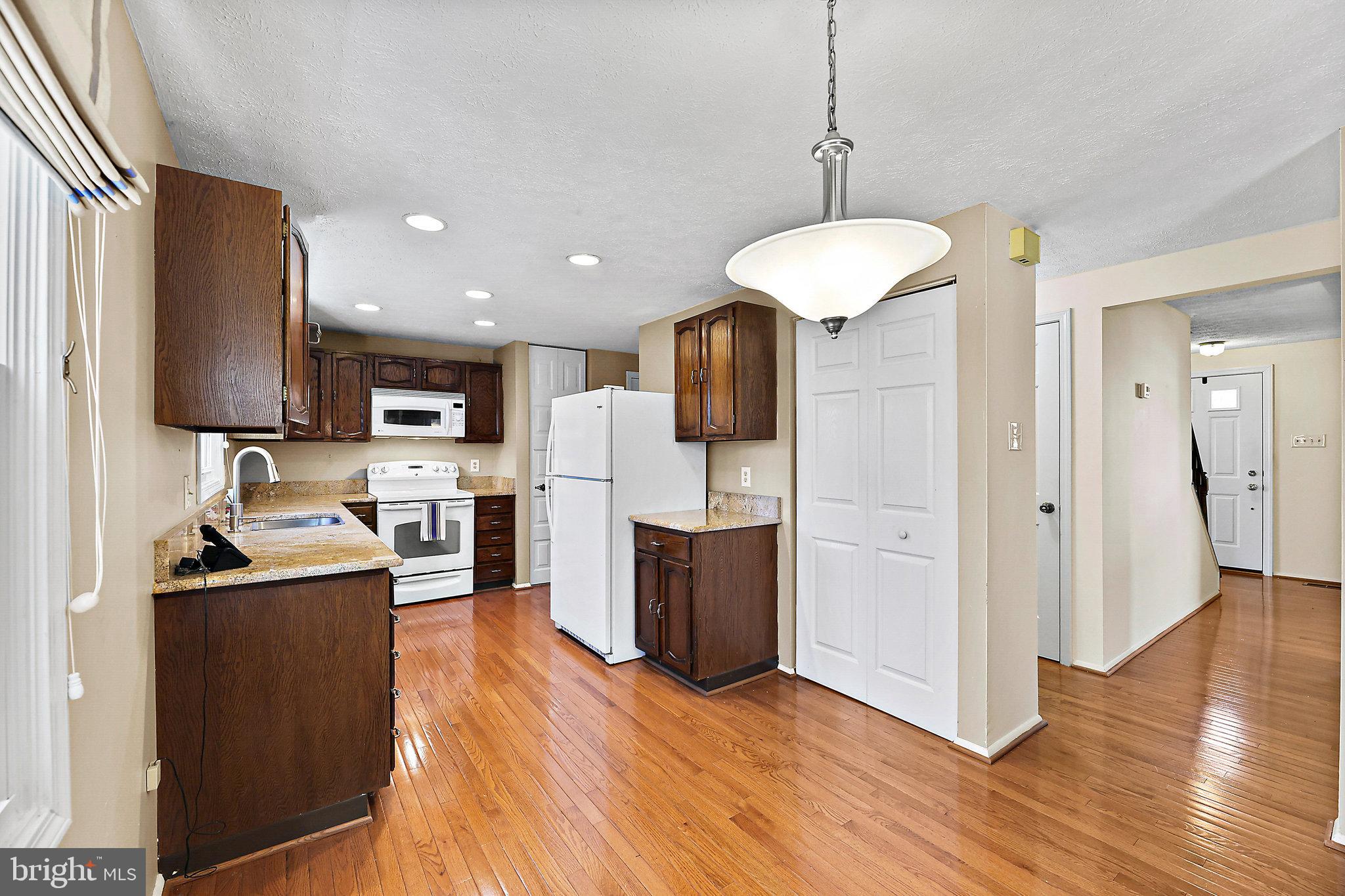 8470 Falling Leaf Road Springfield, VA 22153 - Photo 15 of 41 a kitchen with stainless steel appliances granite countertop a refrigerator a stove top oven a sink dishwasher and a refrigerator with wooden floor