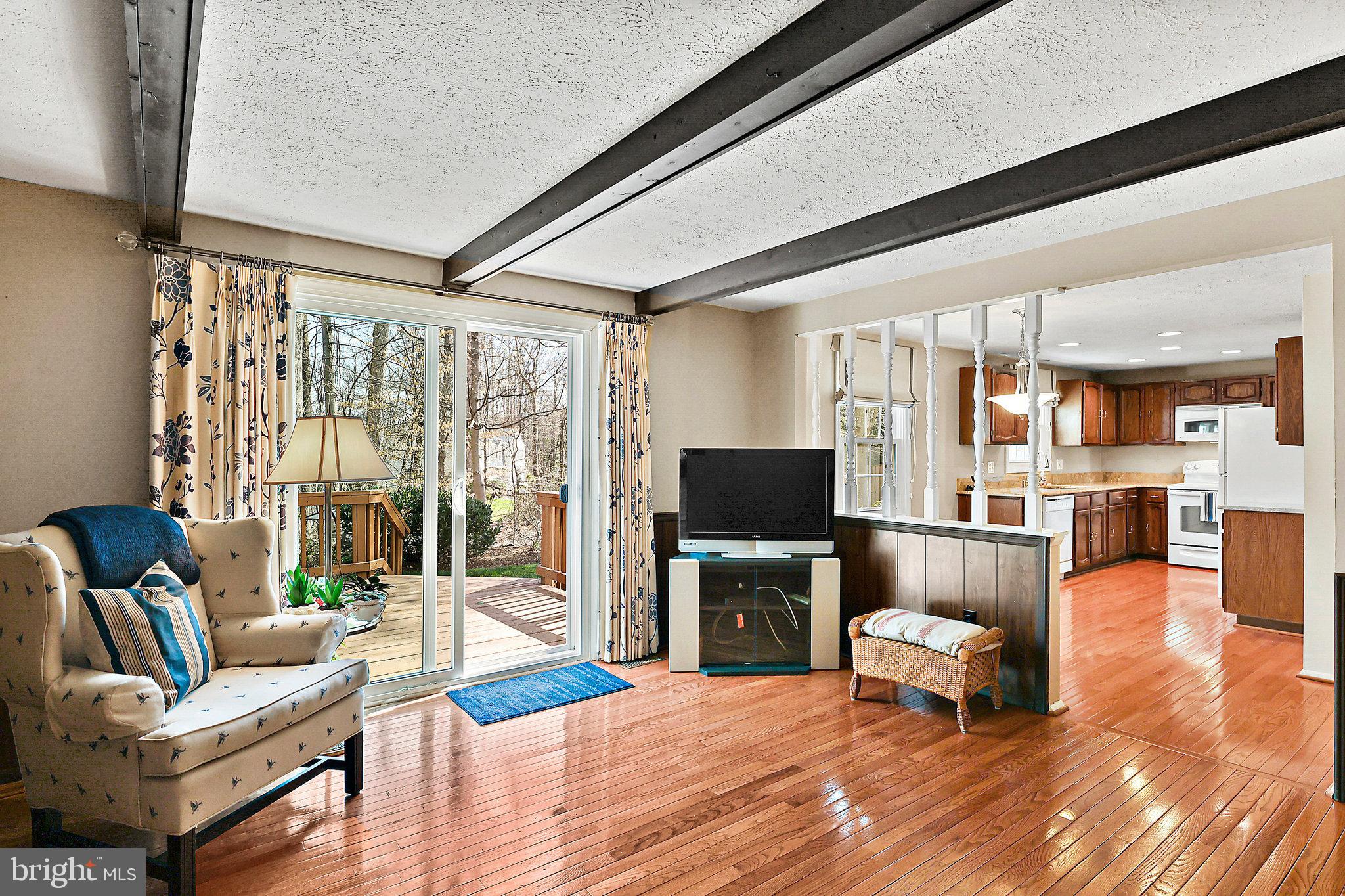 8470 Falling Leaf Road Springfield, VA 22153 - Photo 18 of 41 a living room with furniture a flat screen tv and a floor to ceiling window