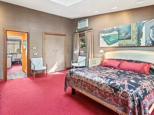 a bedroom with a bed and large windows