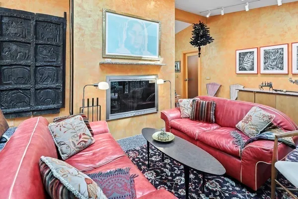 a living room with furniture a flat screen tv and a fireplace