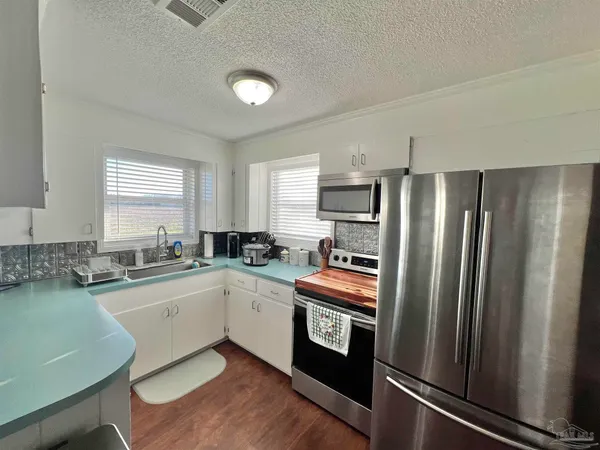a kitchen with a sink appliances and cabinets