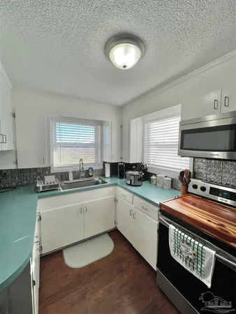 a kitchen with stainless steel appliances granite countertop a sink stove and cabinets