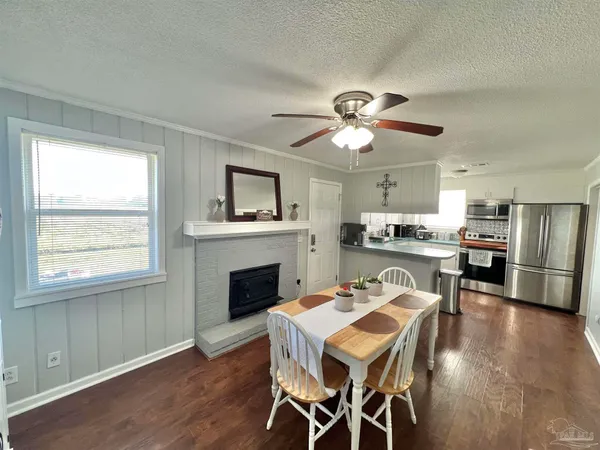 a view of a dining room with furniture a chandelier and wooden floor