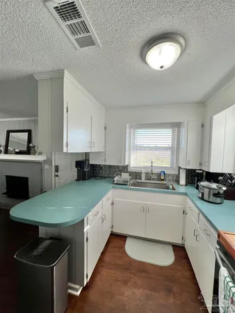 a kitchen with a sink cabinets and wooden floor